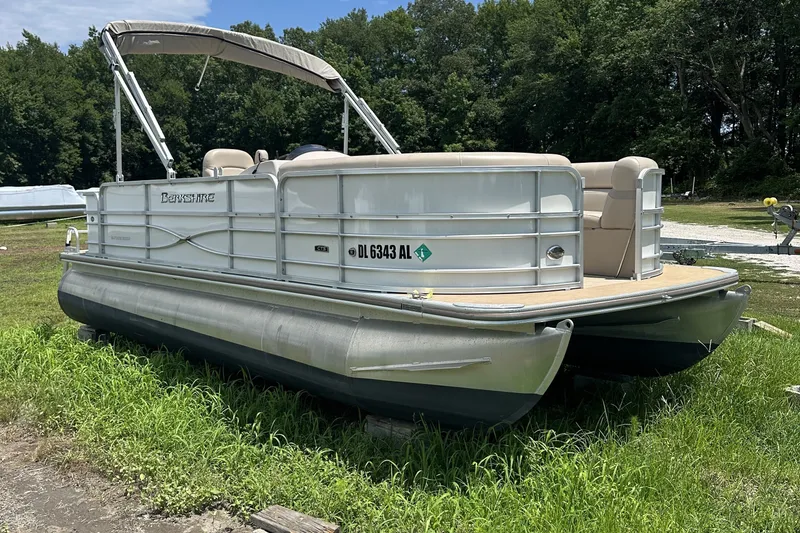 The Image of 2018 Berkshire 22RFC CTS pontoon boat on grass, featuring beige seating and canopy. - 1