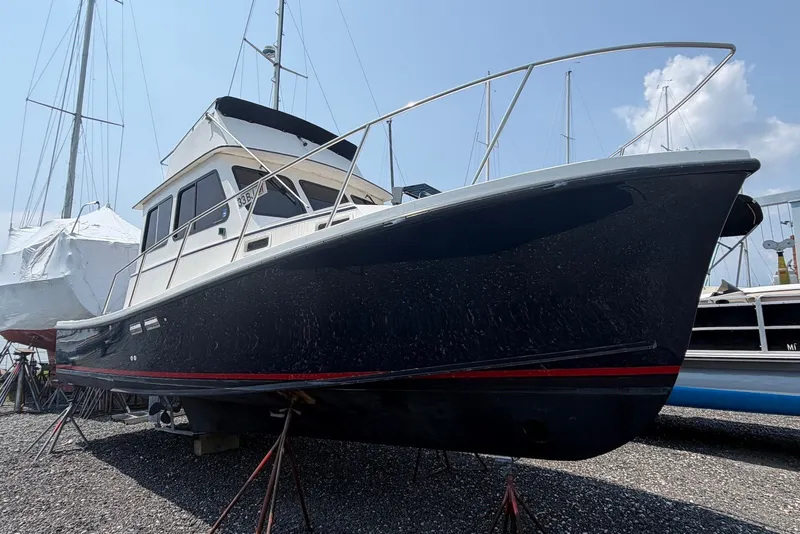 Slide: The Image of 1999 Judge Eastern 31 Flybridge boat on dry dock, side view. - 2