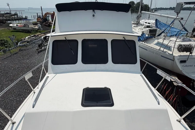 Slide: The Image of 1999 Judge Eastern 31 Flybridge boat docked, with visible flybridge and surrounding marina. - 15