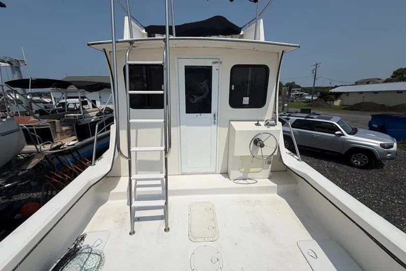 Slide: The Image of 1999 Judge Eastern 31 Flybridge boat with ladder and deck view in a marina setting. - 5