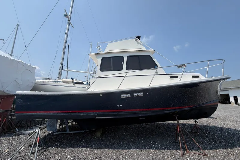 The Image of 1999 Judge Eastern 31 Flybridge boat on stands, displayed outdoors under clear sky. - 0
