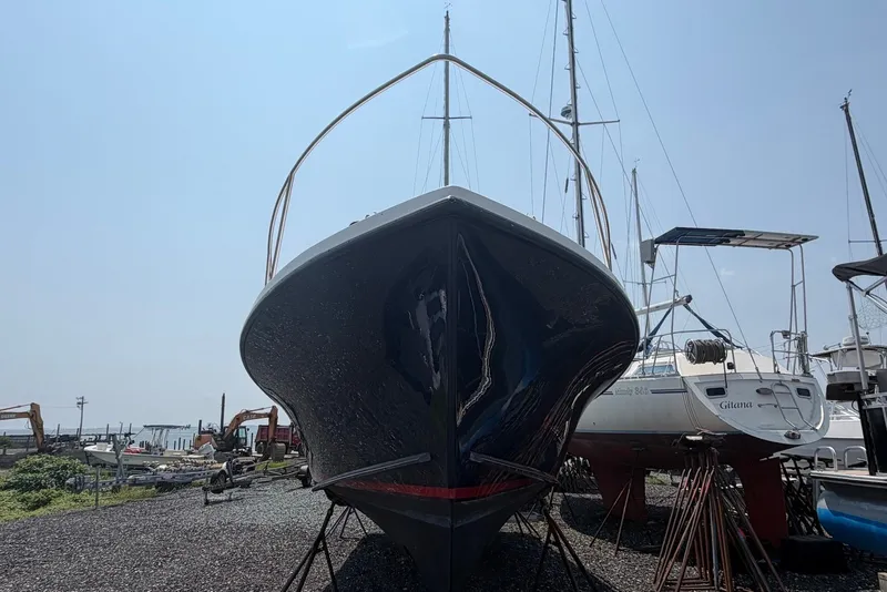 Slide: The Image of 1999 Judge Eastern 31 Flybridge boat on dry dock, surrounded by other vessels. - 3