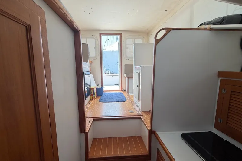 Slide: The Image of Interior view of 1999 Judge Eastern 31 Flybridge boat with wooden flooring and compact layout. - 12
