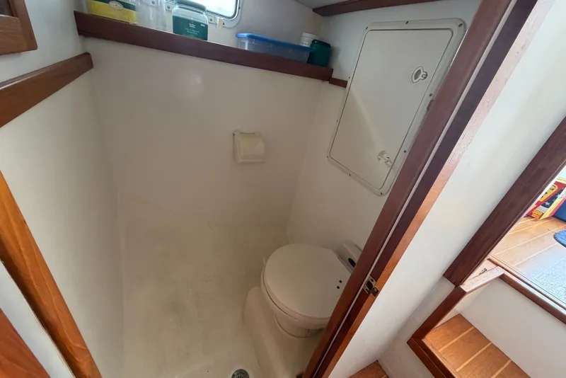 Slide: The Image of Boat bathroom interior of 1999 Judge Eastern 31 Flybridge, featuring compact design and wooden accents. - 14