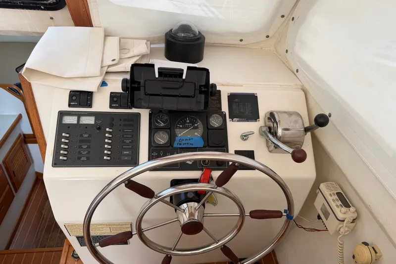 Slide: The Image of Control panel of a 1999 Judge Eastern 31 Flybridge boat with steering wheel and gauges. - 7