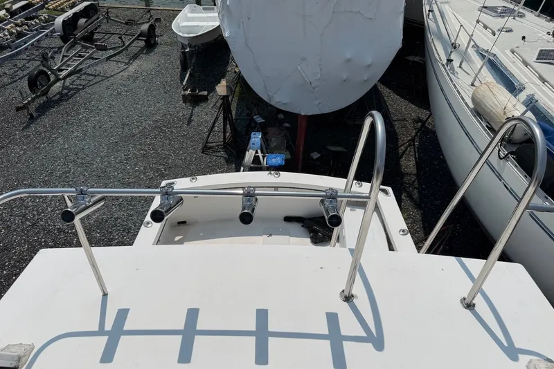 Slide: The Image of 1999 Judge Eastern 31 Flybridge boat on dry dock with metal railings and rod holders. - 17