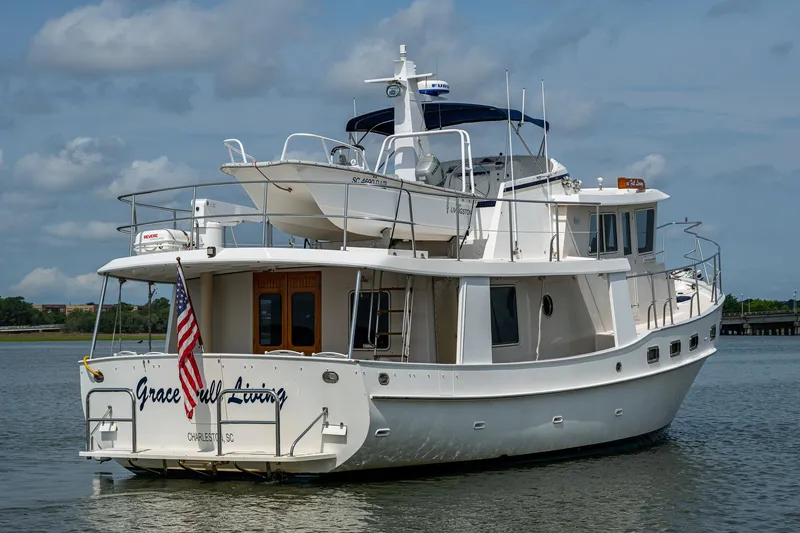 Slide: The Image of Kadey-Krogen 48 North Sea yacht, 2000 model, anchored on calm water with American flag. - 1