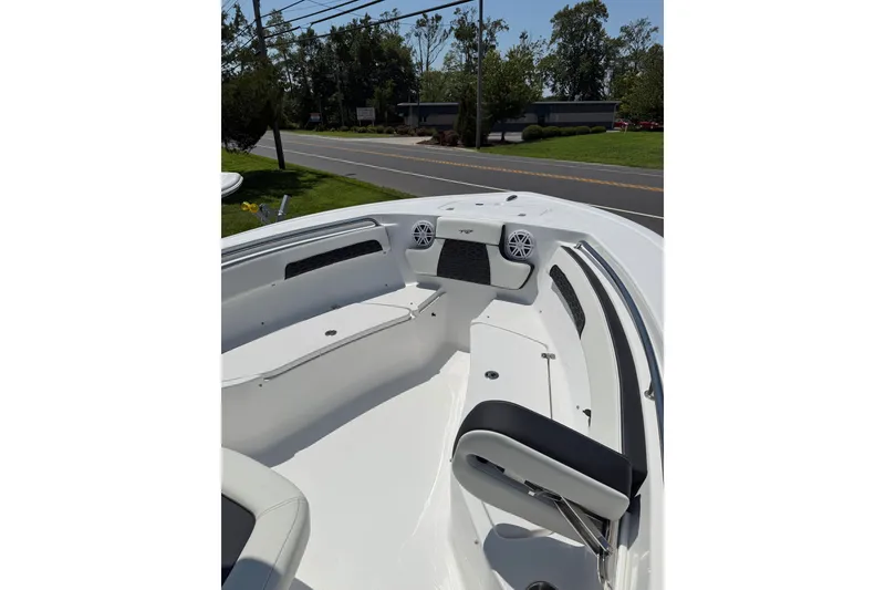 Slide: The Image of 2027 Tidewater 220 CC Adventure boat interior with seating and speakers, parked near a road. - 3