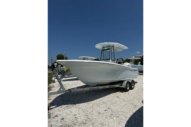 Slide: The Image of 2027 Tidewater 220 CC Adventure boat on trailer under clear blue sky. - 1
