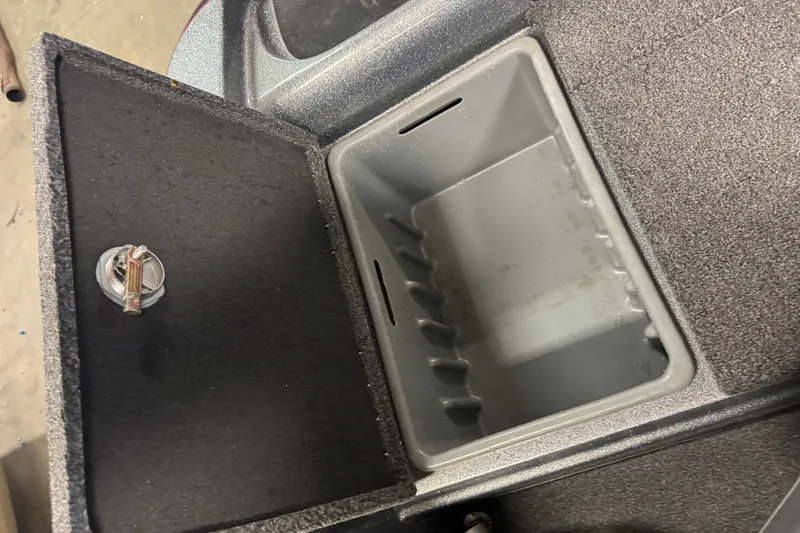 Slide: The Image of Open storage compartment in a 2019 Nitro ZV19 boat, featuring a secure latch. - 12