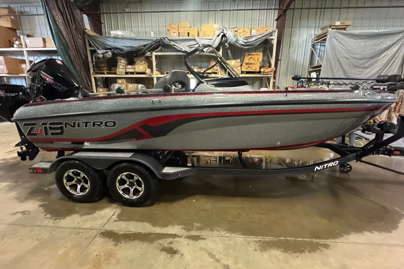 The Image of 2019 Nitro ZV19 boat in warehouse, featuring sleek design and dual-axle trailer. - 0