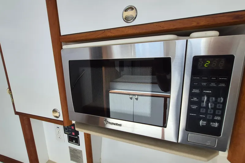 Slide: The Image of Microwave in 2005 Endeavour 44 TrawlerCat kitchen, featuring wood accents and control panel. - 45