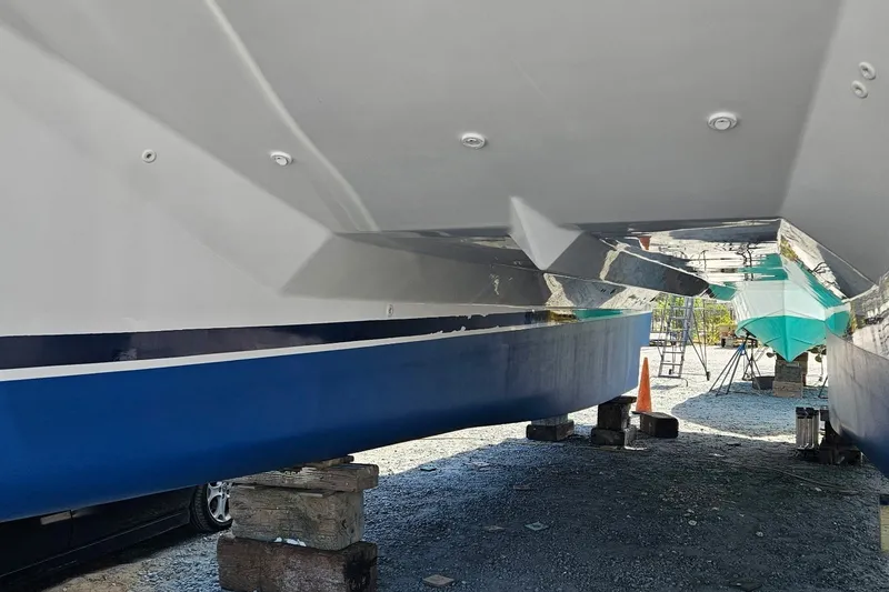 Slide: The Image of 2005 Endeavour 44 TrawlerCat hull on dry dock, showcasing underside and supports. - 83
