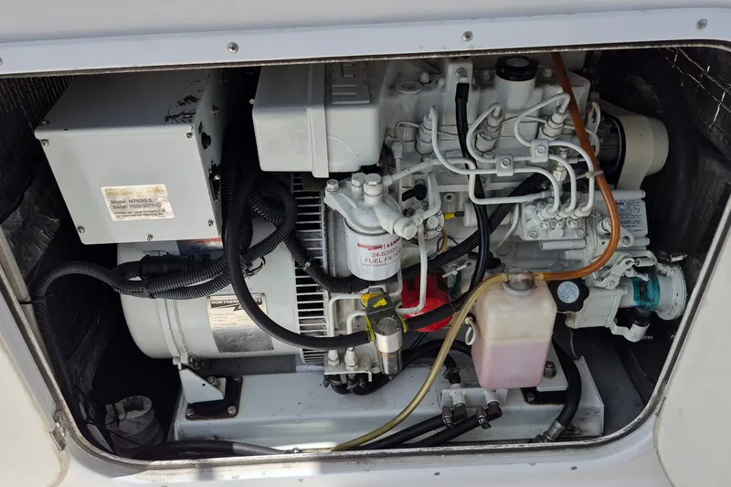 Slide: The Image of Engine compartment of a 2005 Endeavour 44 TrawlerCat, showcasing mechanical components and wiring. - 57
