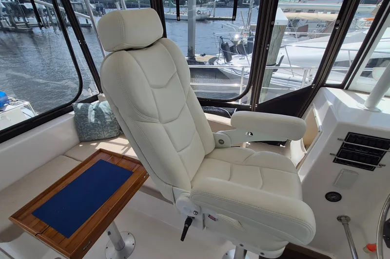 Slide: The Image of Captain's chair in 2005 Endeavour 44 TrawlerCat, overlooking marina through large windows. - 8