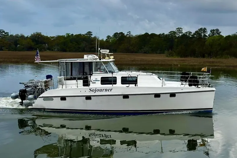 The Image of 2005 Endeavour 44 TrawlerCat cruising on calm waters with scenic background. - 1