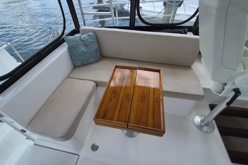 Slide: The Image of Cozy seating area on 2005 Endeavour 44 TrawlerCat with wooden table and cushion. - 3