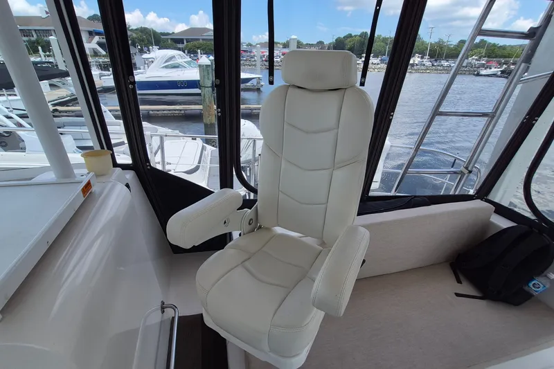 Slide: The Image of Captain's chair on 2005 Endeavour 44 TrawlerCat, overlooking marina with boats. - 7