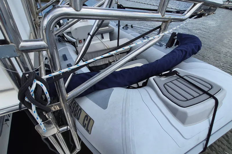 Slide: The Image of 2005 Endeavour 44 TrawlerCat with dinghy and stainless steel railing, docked by the water. - 61