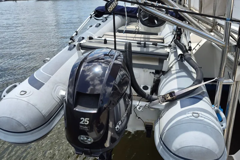 Slide: The Image of Inflatable boat with outboard motor on Endeavour 44 TrawlerCat, 2005 model, docked on water. - 60
