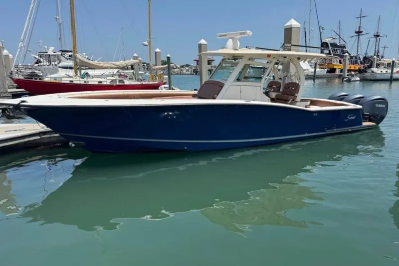 Slide: The Image of 2017 Scout 350 LXF boat docked in marina with clear blue water. - 43