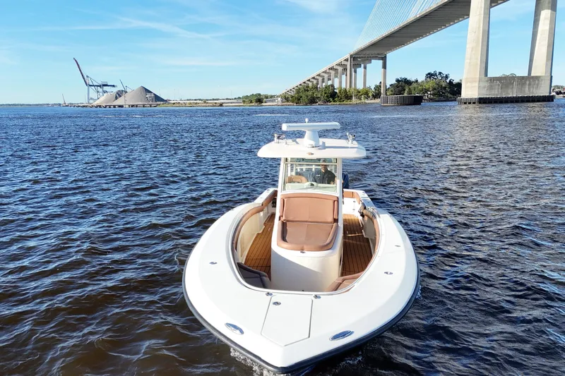 Slide: The Image of 2017 Scout 350 LXF boat cruising under a bridge on a sunny day. - 14