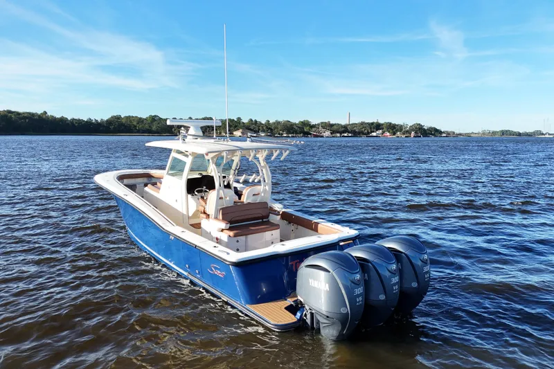 Slide: The Image of 2017 Scout 350 LXF boat with triple Yamaha engines on a sunny day. - 18