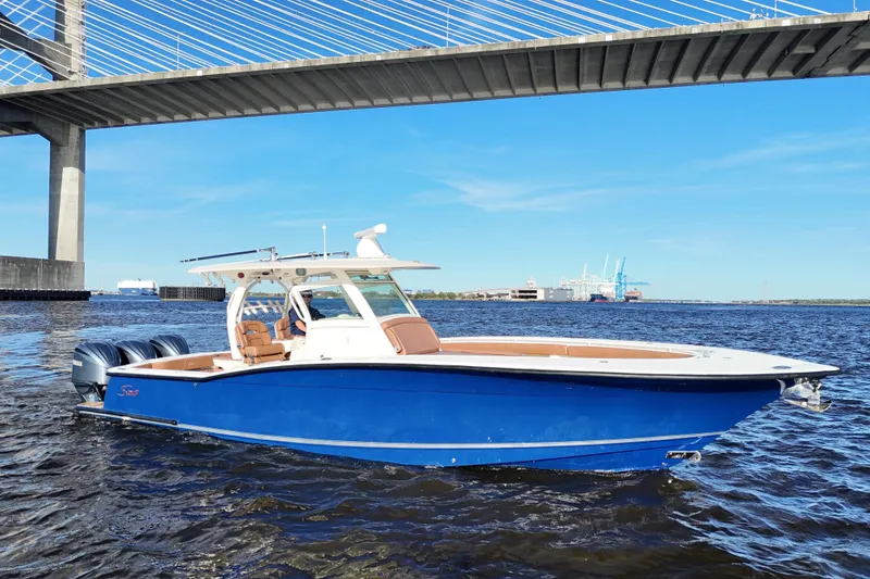 Slide: The Image of 2017 Scout 350 LXF boat on water under bridge, clear sky background. - 9