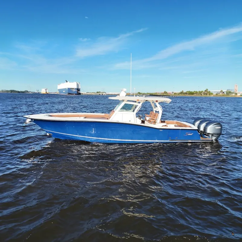 The Image of 2017 Scout 350 LXF boat on water, blue hull, twin Yamaha engines, clear sky. - 0