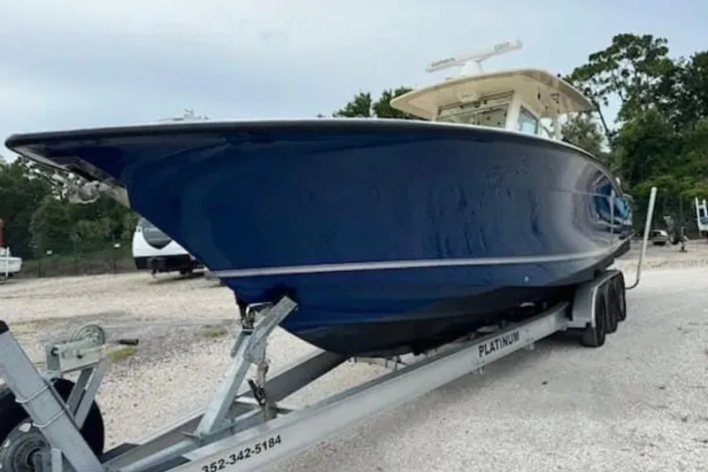 Slide: The Image of 2017 Scout 350 LXF boat on trailer, side view, blue hull. - 77