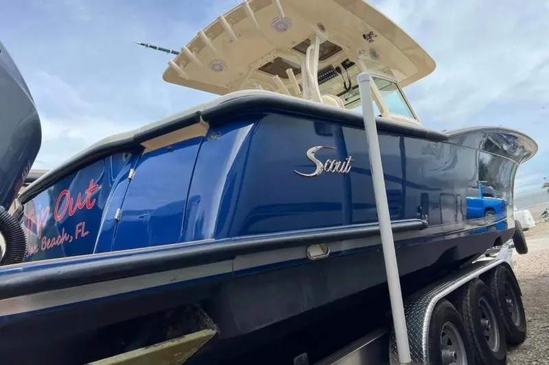 Slide: The Image of 2017 Scout 350 LXF boat with blue hull, parked on a trailer. - 78