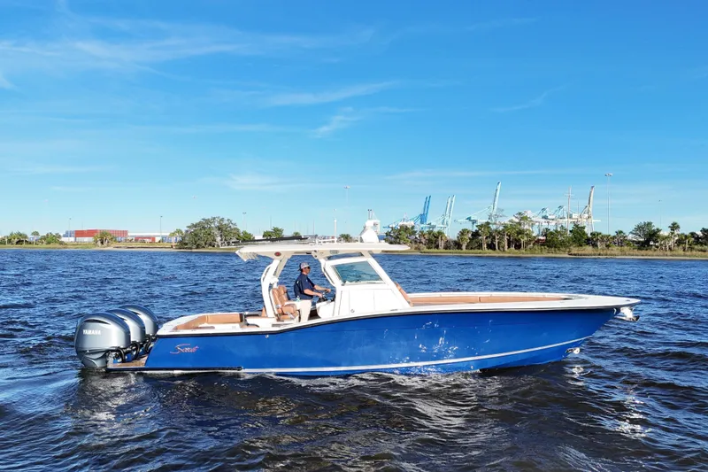 Slide: The Image of 2017 Scout 350 LXF boat cruising on water with blue sky background. - 3