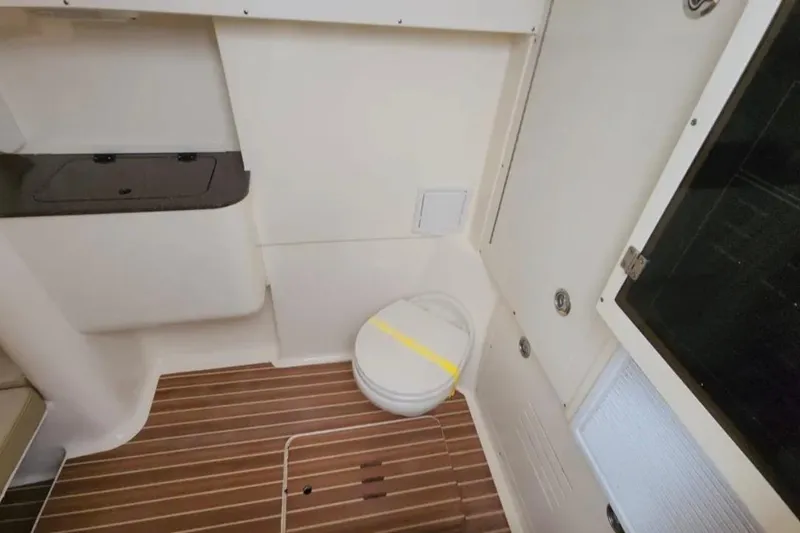 Slide: The Image of 2017 Scout 350 LXF boat interior with wooden flooring and compact toilet. - 73