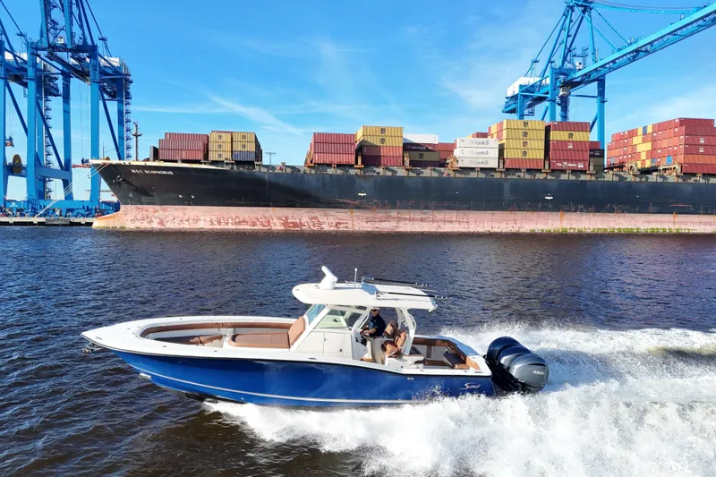Slide: The Image of 2017 Scout 350 LXF boat cruising near container ship and cranes. - 29