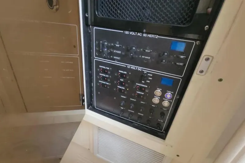 Slide: The Image of Electrical control panel on a 2017 Scout 350 LXF boat, featuring 120V AC and 12V DC systems. - 74