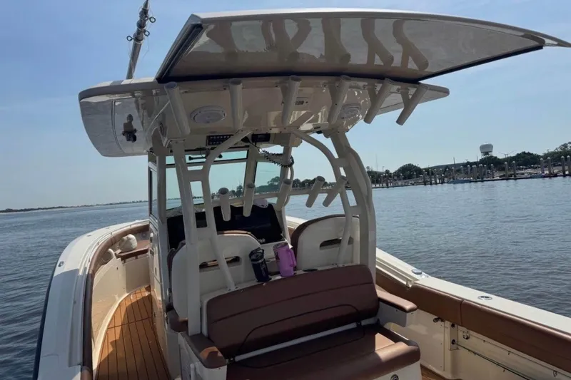 Slide: The Image of 2017 Scout 350 LXF boat on calm water, featuring sleek design and spacious deck. - 68
