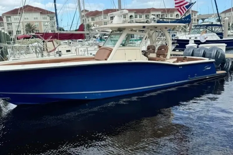 Slide: The Image of 2017 Scout 350 LXF boat docked in marina, featuring sleek blue design and twin engines. - 46