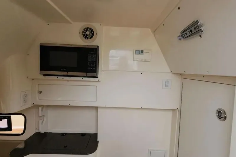 Slide: The Image of Interior of 2017 Scout 350 LXF boat with microwave and storage compartments. - 70