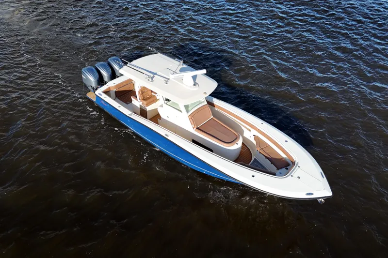 Slide: The Image of 2017 Scout 350 LXF boat cruising on open water, featuring triple outboard engines. - 12