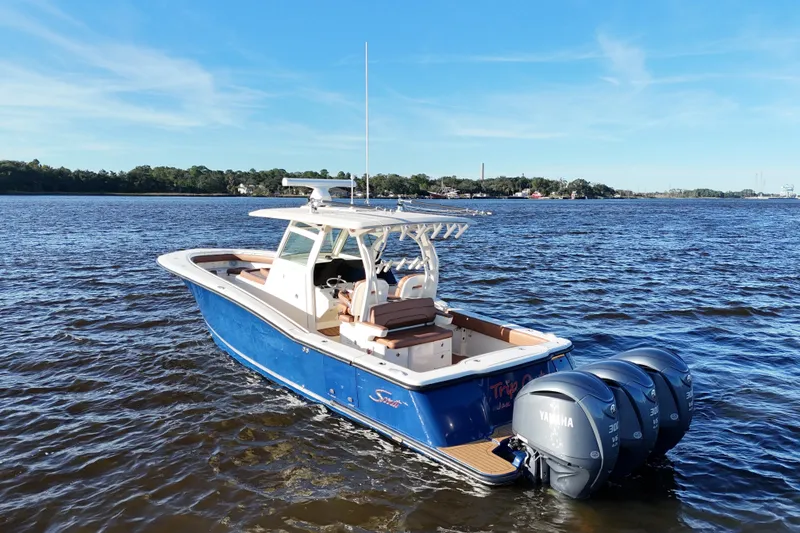 Slide: The Image of 2017 Scout 350 LXF boat with triple Yamaha engines on open water. - 7