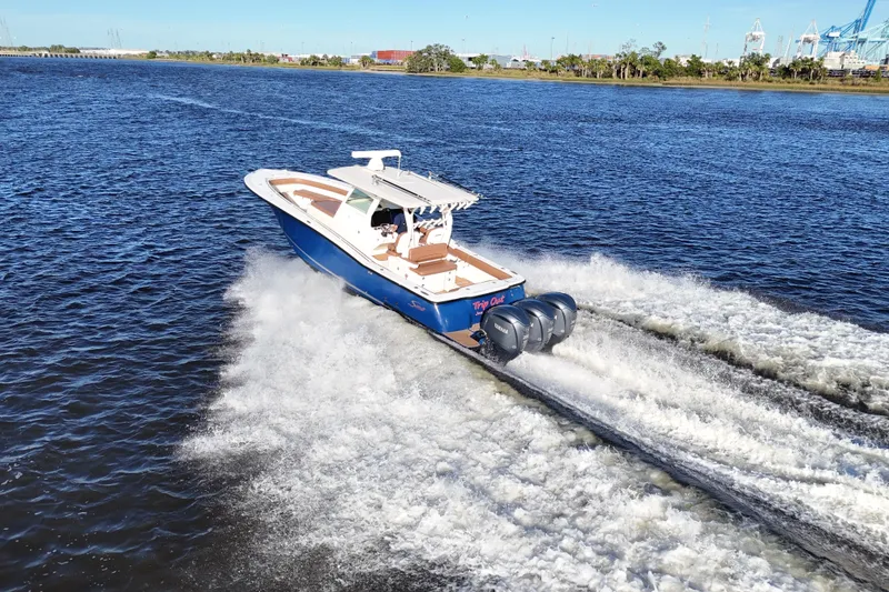 Slide: The Image of 2017 Scout 350 LXF boat cruising on open water with triple engines. - 21