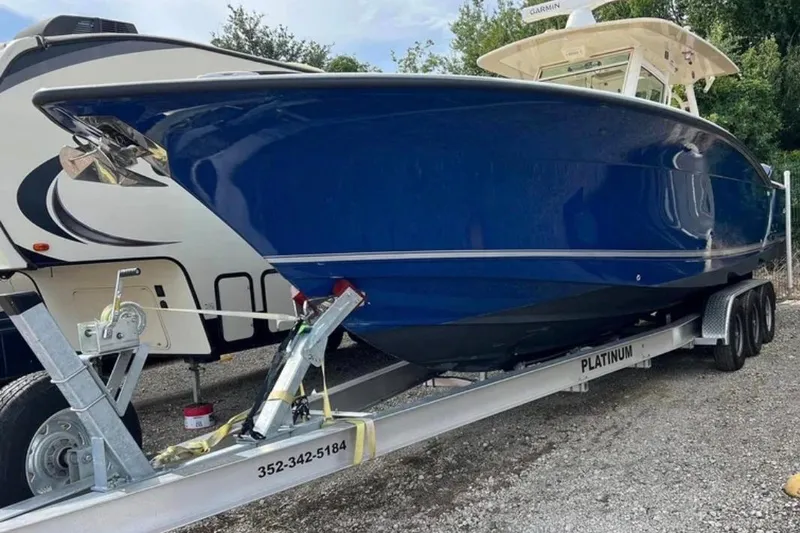 Slide: The Image of 2017 Scout 350 LXF boat on trailer, blue hull, parked outdoors. - 55