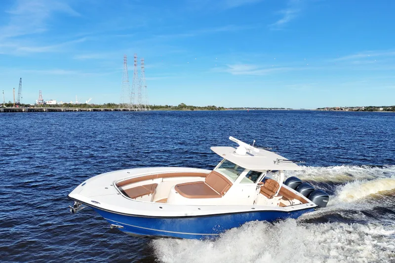 Slide: The Image of 2017 Scout 350 LXF boat cruising on a sunny day, blue water and sky backdrop. - 23
