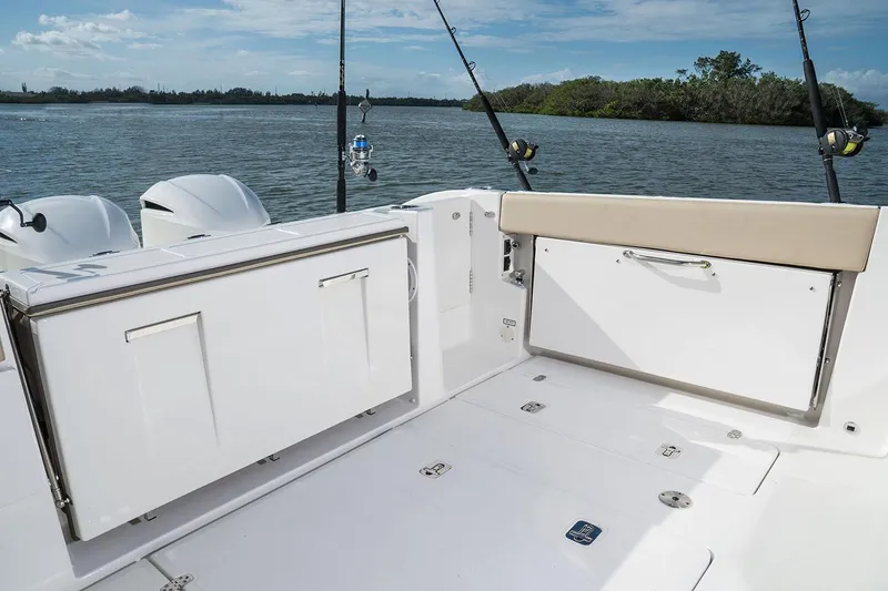 Slide: The Image of Manufacturer Provided Image: 2025 Pursuit DC 365 Dual Console boat deck with fishing rods and storage compartments. - 18