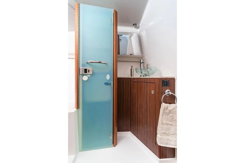 Slide: The Image of Manufacturer Provided Image: 2025 Pursuit DC 365 Dual Console boat bathroom with modern design and wooden cabinetry. - 23