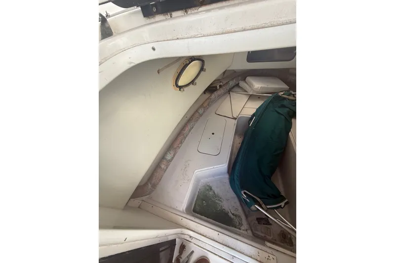 Slide: The Image of Interior of a 1995 PROLINE 211 boat, featuring storage compartments and a green bag. - 15