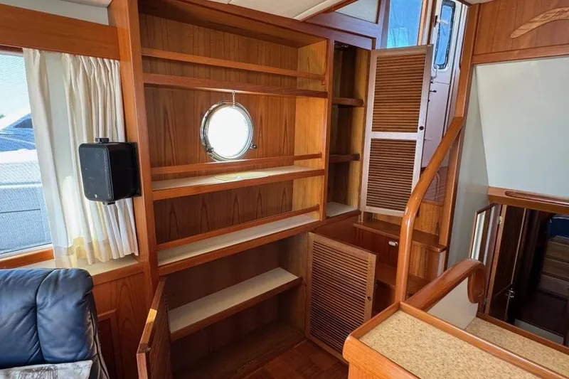 Slide: The Image of Interior of 2008 Kadey-Krogen 44 Walk Around yacht with wooden shelves and porthole. - 30