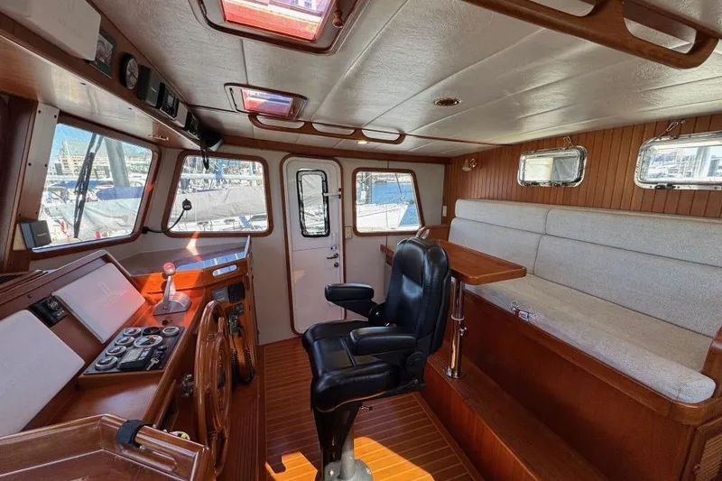Slide: The Image of 2008 Kadey-Krogen 44 Walk Around yacht interior with helm, seating, and wooden accents. - 63