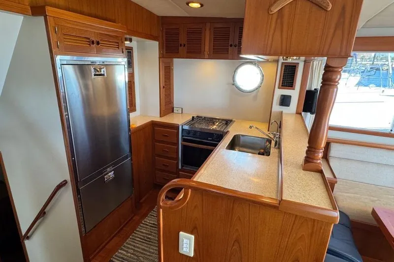 Slide: The Image of 2008 Kadey-Krogen 44 Walk Around yacht kitchen with wood cabinetry and stainless steel appliances. - 33