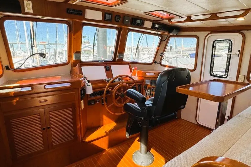 Slide: The Image of 2008 Kadey-Krogen 44 Walk Around yacht interior with wooden helm and seating. - 62